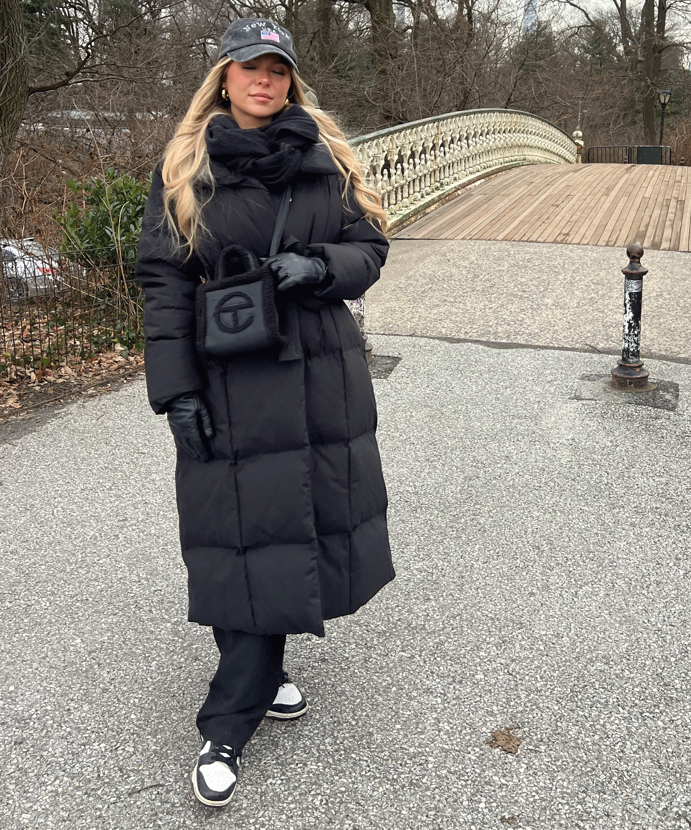 Women's long black puffer coat with hood, belted waist and front pockets