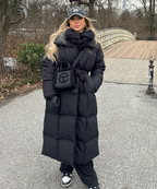 Women's long black puffer coat with hood and belted front, quilted insulation