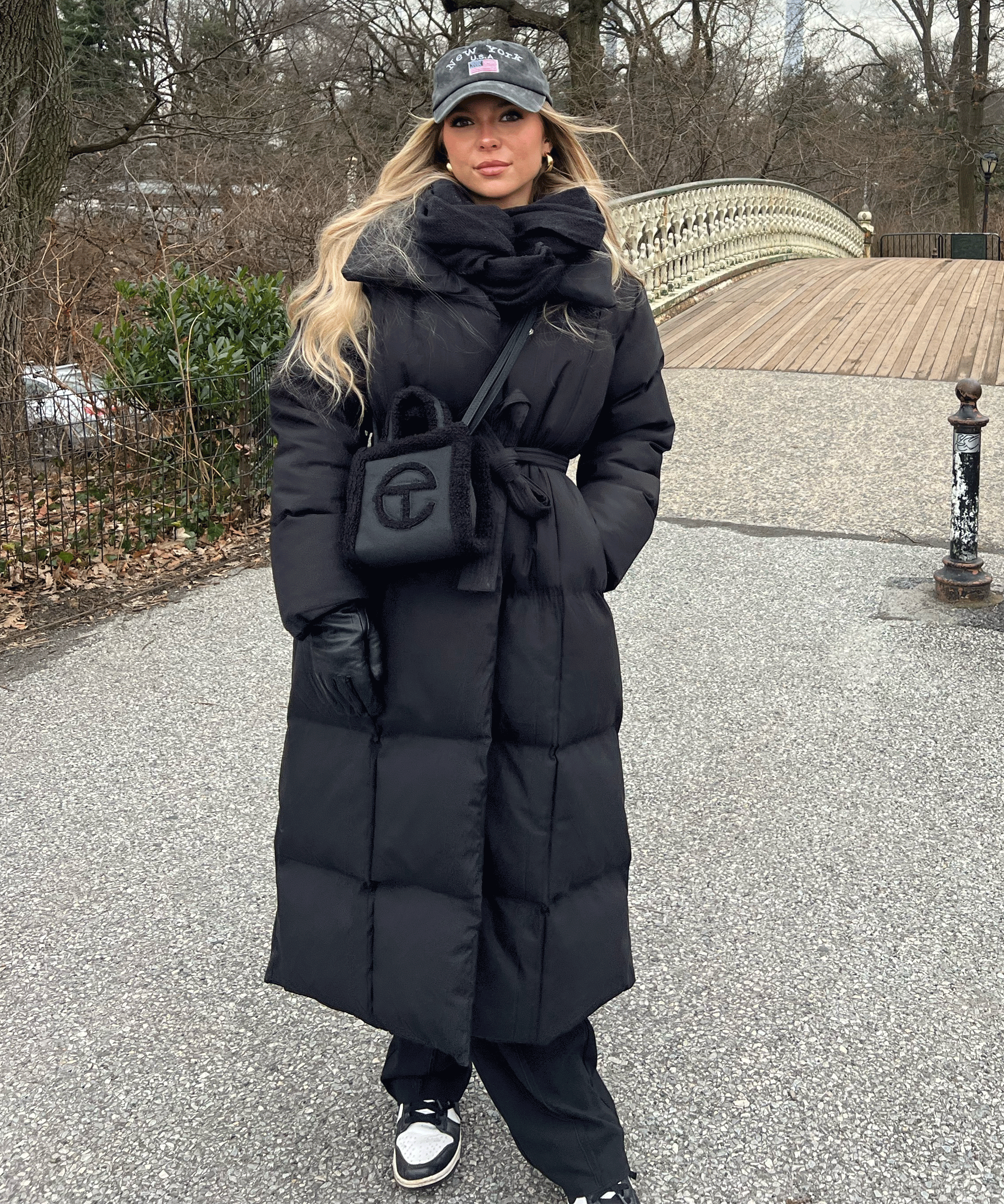 Women's long black puffer coat with hood and belted front, quilted insulation