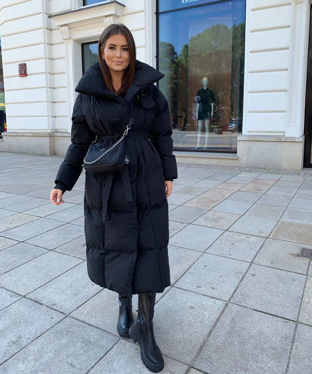 Women's long black hooded puffer coat with tie belt and padded, quilted front