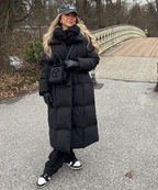 Women's long black puffer coat with hood, belted waist and quilted texture