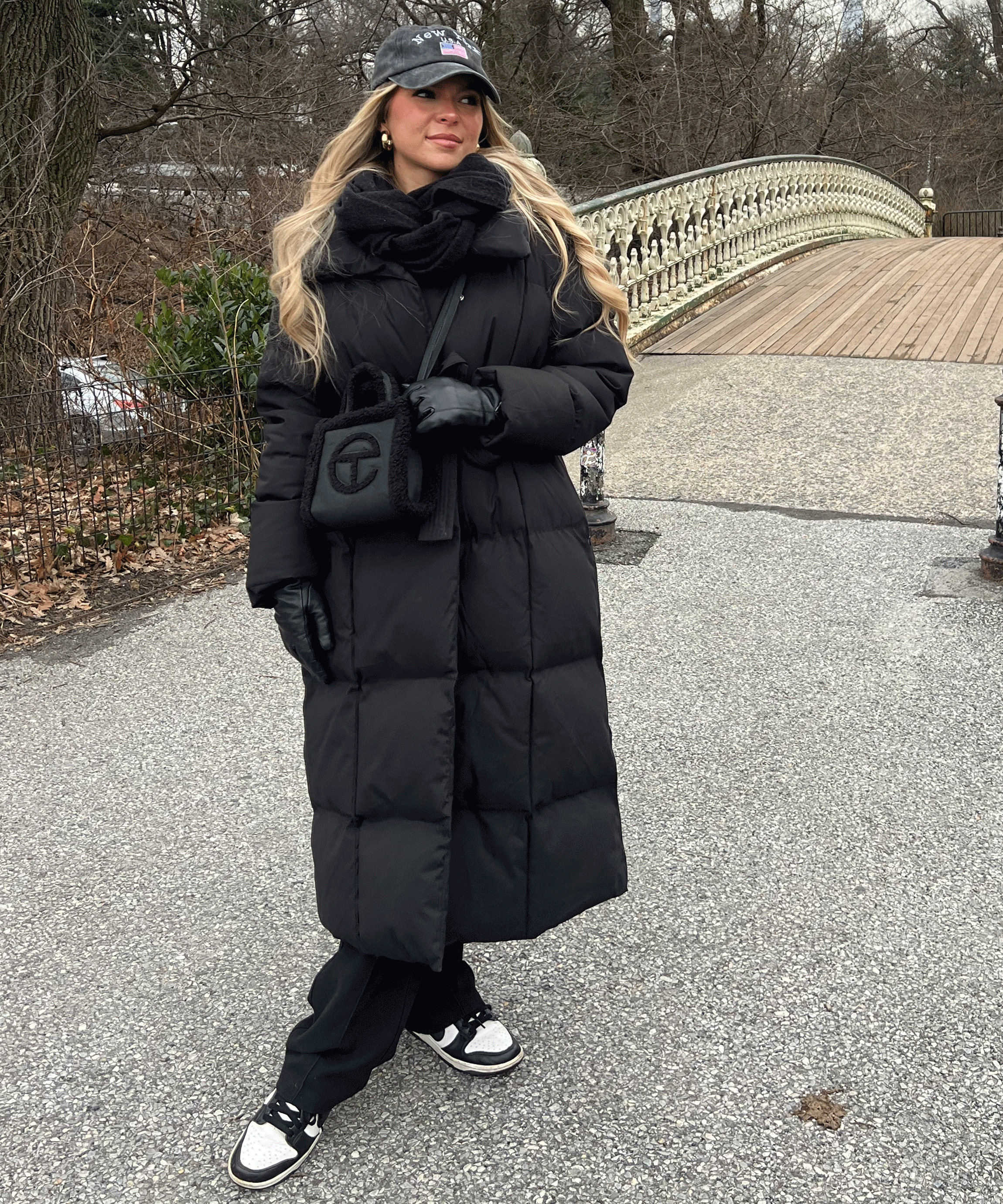 Women's long black puffer coat with hood, belted waist and quilted texture
