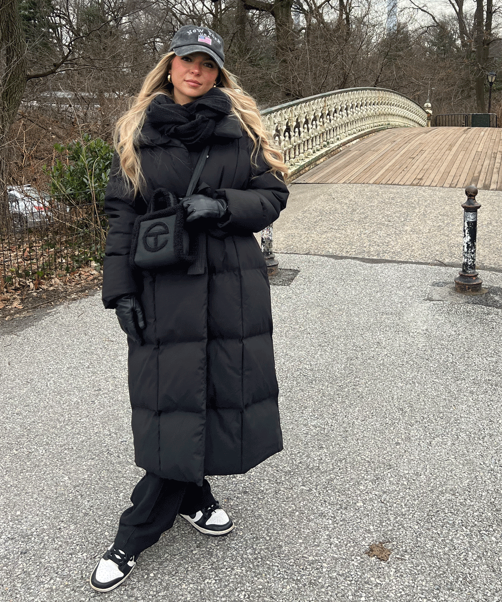 Black long puffer coat with hood and tie belt, quilted insulation and mid-ankle hem