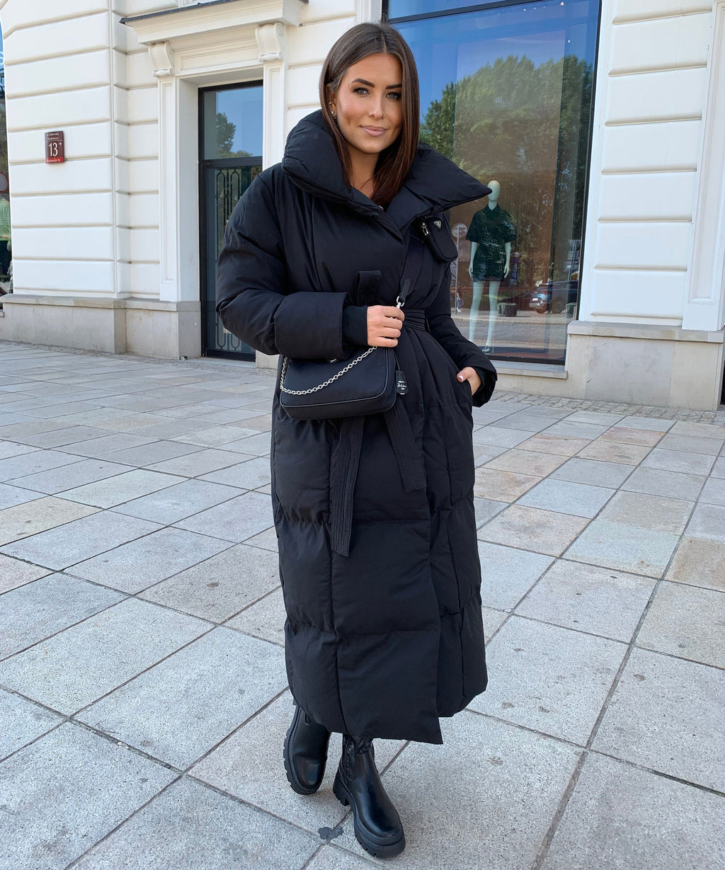Black maxi puffer coat with hood, tie belt at waist, quilted texture and front zip