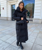 Black maxi puffer coat with hood, tie belt at waist, quilted texture and front zip