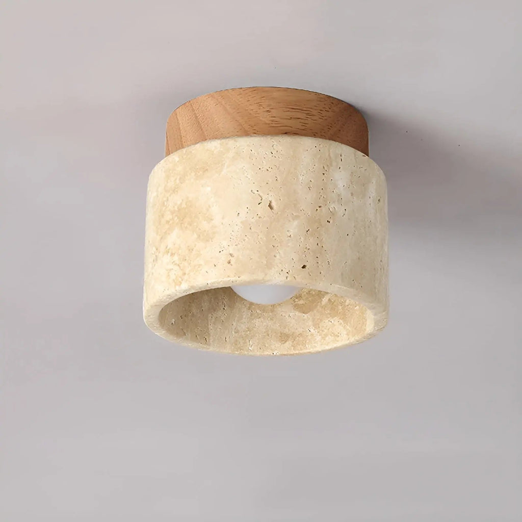 Flush mount ceiling lamp with travertine cylinder shade and light wood top ring.
