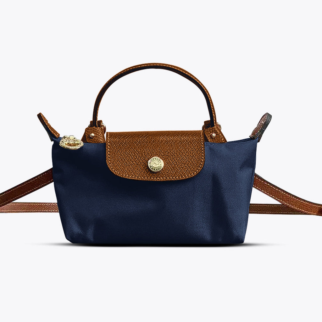 Mini crossbody shoulder bag in navy blue with brown flap and gold-tone front clasp, adjustable strap
