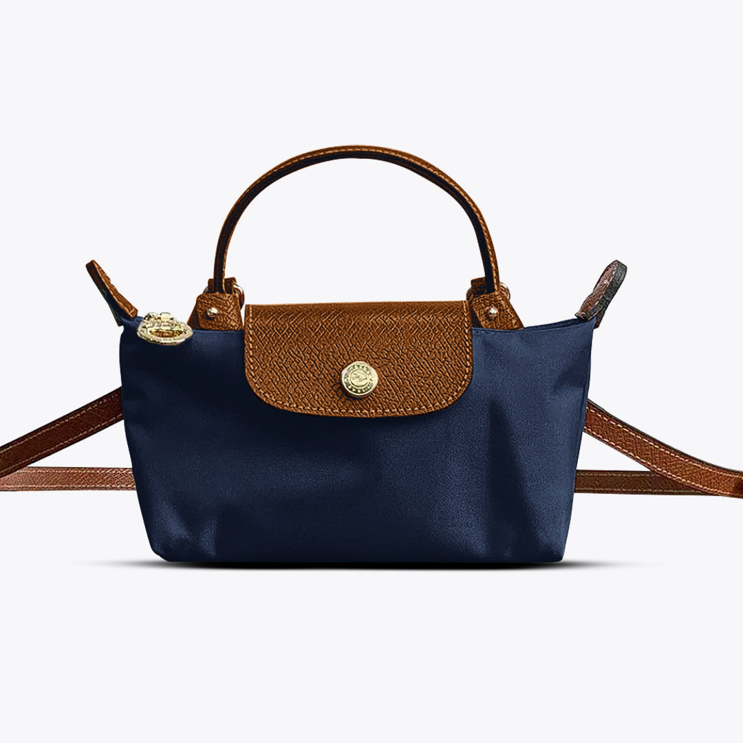 Mini crossbody shoulder bag in navy blue with brown flap and gold-tone front clasp, adjustable strap