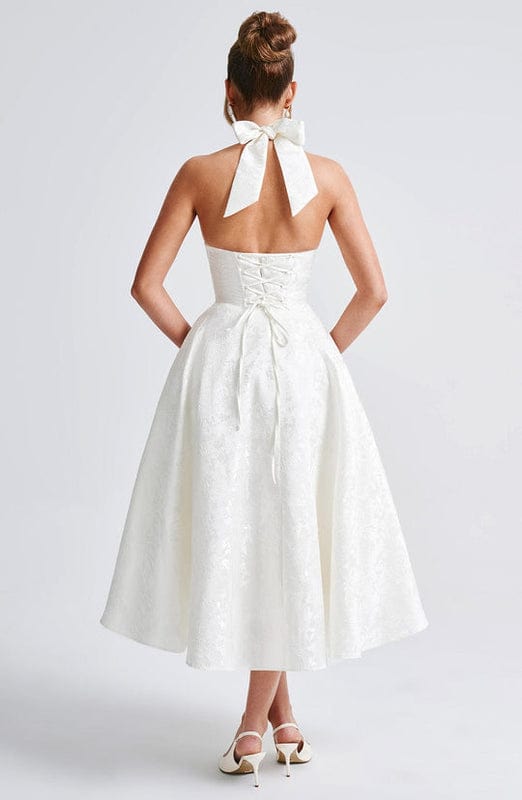 White sleeveless A-line midi dress, open back with bow tie at upper back.