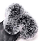 Dark leather gloves with plush gray faux fur cuffs and palm-side seams.