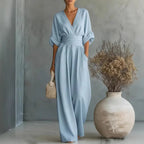 Light blue V-neck summer jumpsuit with short sleeves, cinched waist, and wide legs