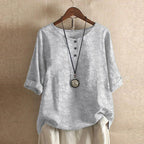 Women’s blouse in light gray with subtle floral pattern, short sleeves, button front