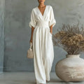 White V-neck summer jumpsuit with short sleeves, cinched waist, and wide legs