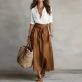 Linen co-ord set with white V-neck blouse and brown tie-waist midi skirt