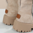 Beige women’s ankle boots close-up with side zipper and tan pull tab detail
