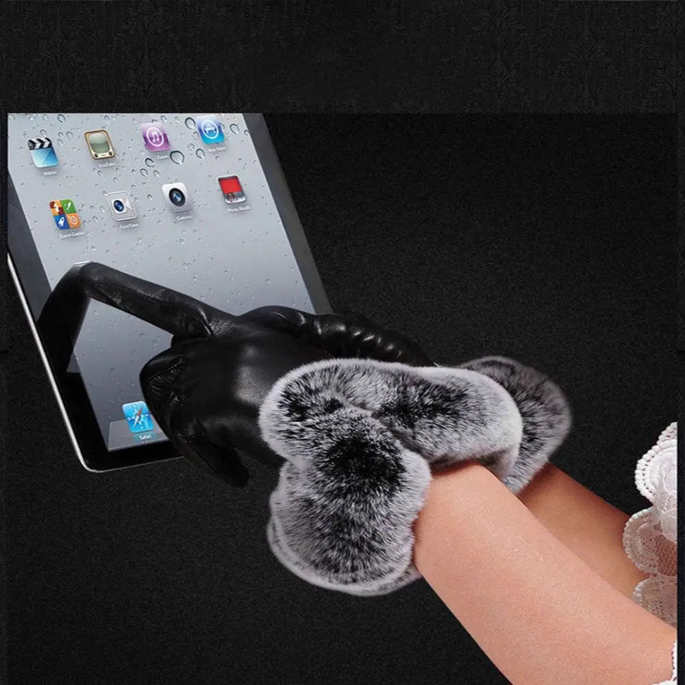 Black leather glove with gray faux fur cuff shown over a hand holding a phone.