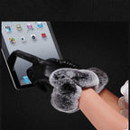 Black leather glove with gray faux fur cuff shown over a hand holding a phone.