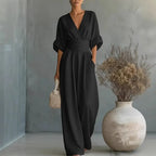 Black V-neck summer jumpsuit with short sleeves, cinched waist, and wide legs