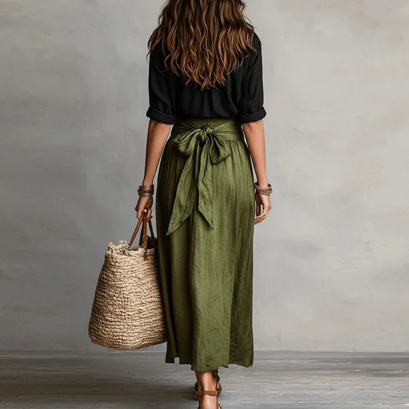 Linen co-ord set with black blouse and olive green tie-front midi skirt, back view