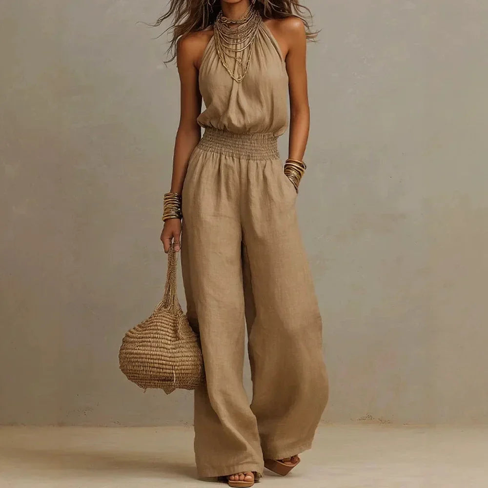 Beige sleeveless wide-leg jumpsuit with smocked waist and loose flowing wide legs.