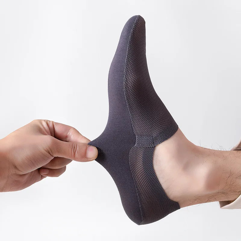 Dark gray no-show socks on foot, hand holding heel area
