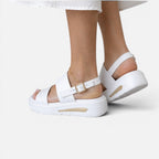 White platform sandals showing adjustable buckle on top strap and thick sole