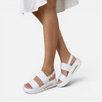 White platform slide sandals with adjustable ankle buckle and thick sole