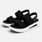 Pair of black platform sandals with wide straps, adjustable buckle, and thick sole