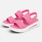 Pair of pink platform sandals with wide straps, adjustable buckle, and thick sole