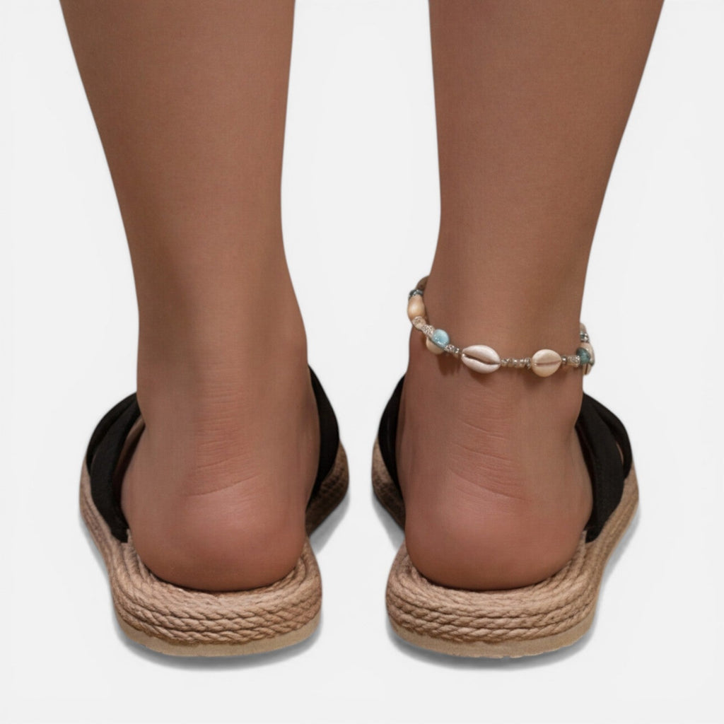 Women’s black cross-strap espadrille slide sandals with shell bead ankle bracelet