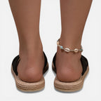 Women’s black cross-strap espadrille slide sandals with shell bead ankle bracelet