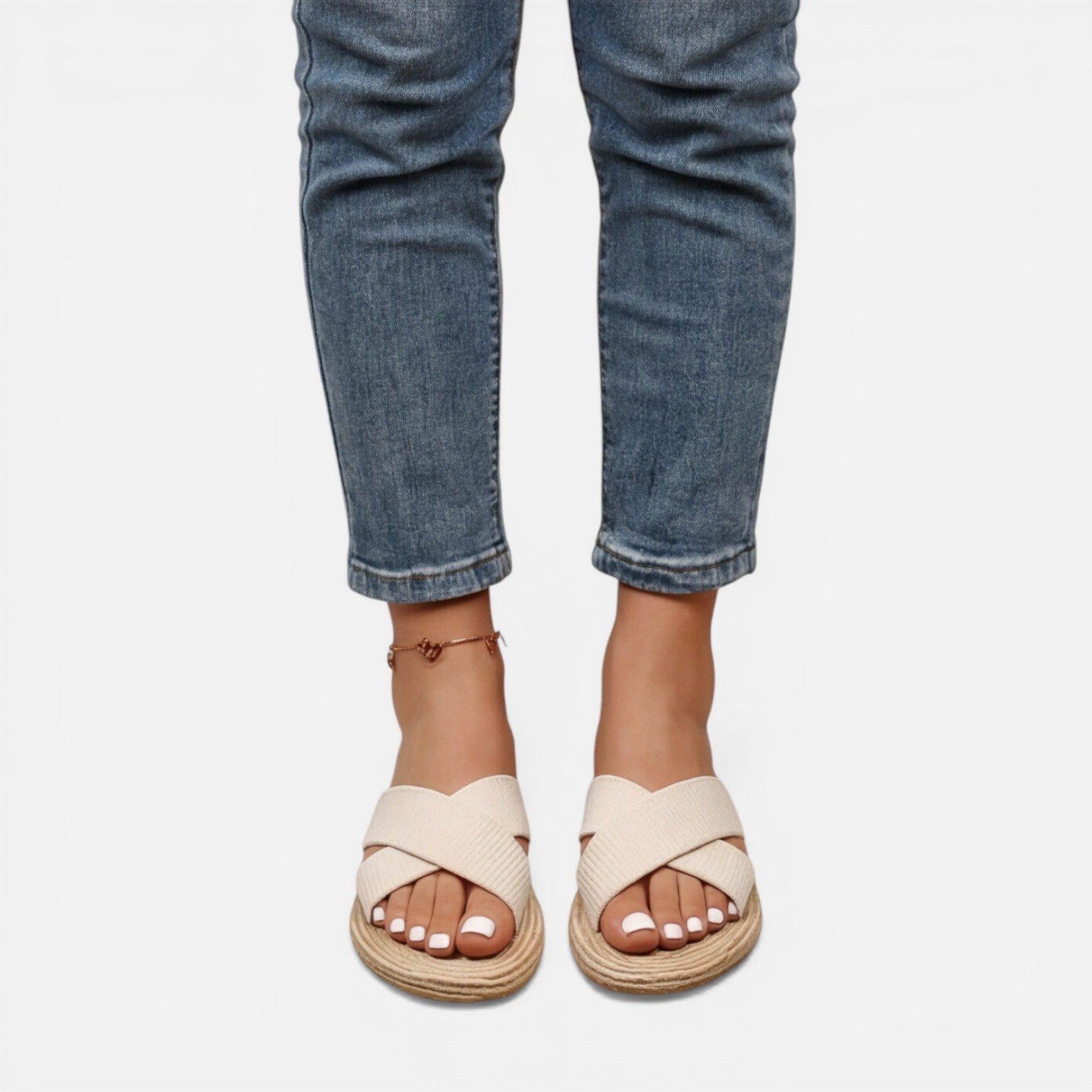 Women’s beige cross-strap espadrille slide sandals worn with rolled denim jeans