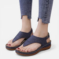 Women’s navy wedge sandals with cutout upper and brown bottom sole