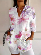 Women's abstract print blouse with button front, white base with pink and purple flowers.