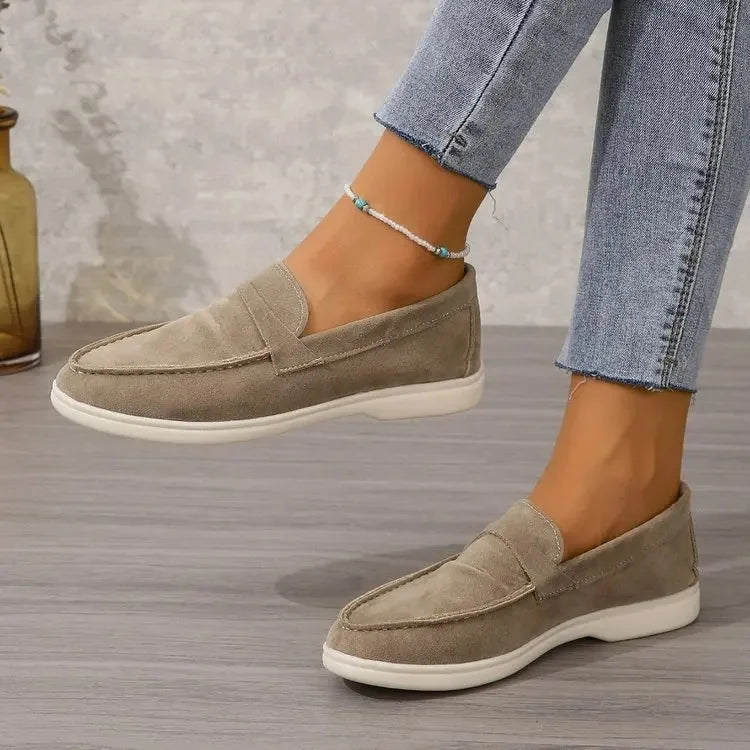 Beige suede slip-on loafers with moc-toe detail and white rubber sole