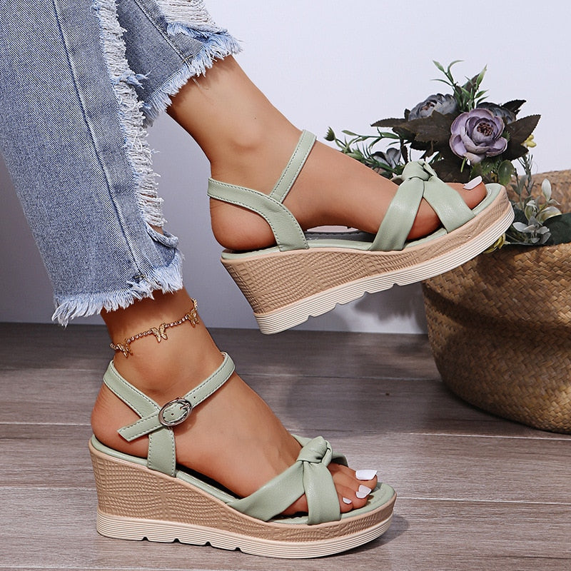 Light green platform wedge sandals with ankle strap buckle and bow detail