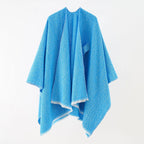 Bright blue cashmere poncho with V-neck, draped sleeves, fringe hem