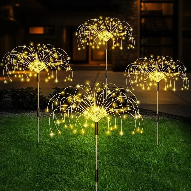 Solar pathway stake LED lights with bright golden white glow from round fan heads on stakes.