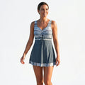 Dark blue tankini set with blue patterned bodice, V-neck tie front and short skirt