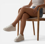 Felorro women's white sneakers with lace-up front and chunky sole, seated legs
