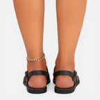 Black strappy toe-loop flat sandals with ankle strap and low-profile sole