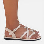 Beige women’s toe-loop flat sandals with ankle strap and buckle, open toe