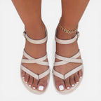 Beige strappy toe-loop flat sandals with crisscross straps and ankle strap