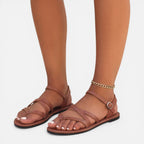 Brown toe-loop flat sandals with ankle strap and ring buckle, open toe