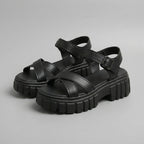 Black platform sandals with crisscross straps and chunky lug sole