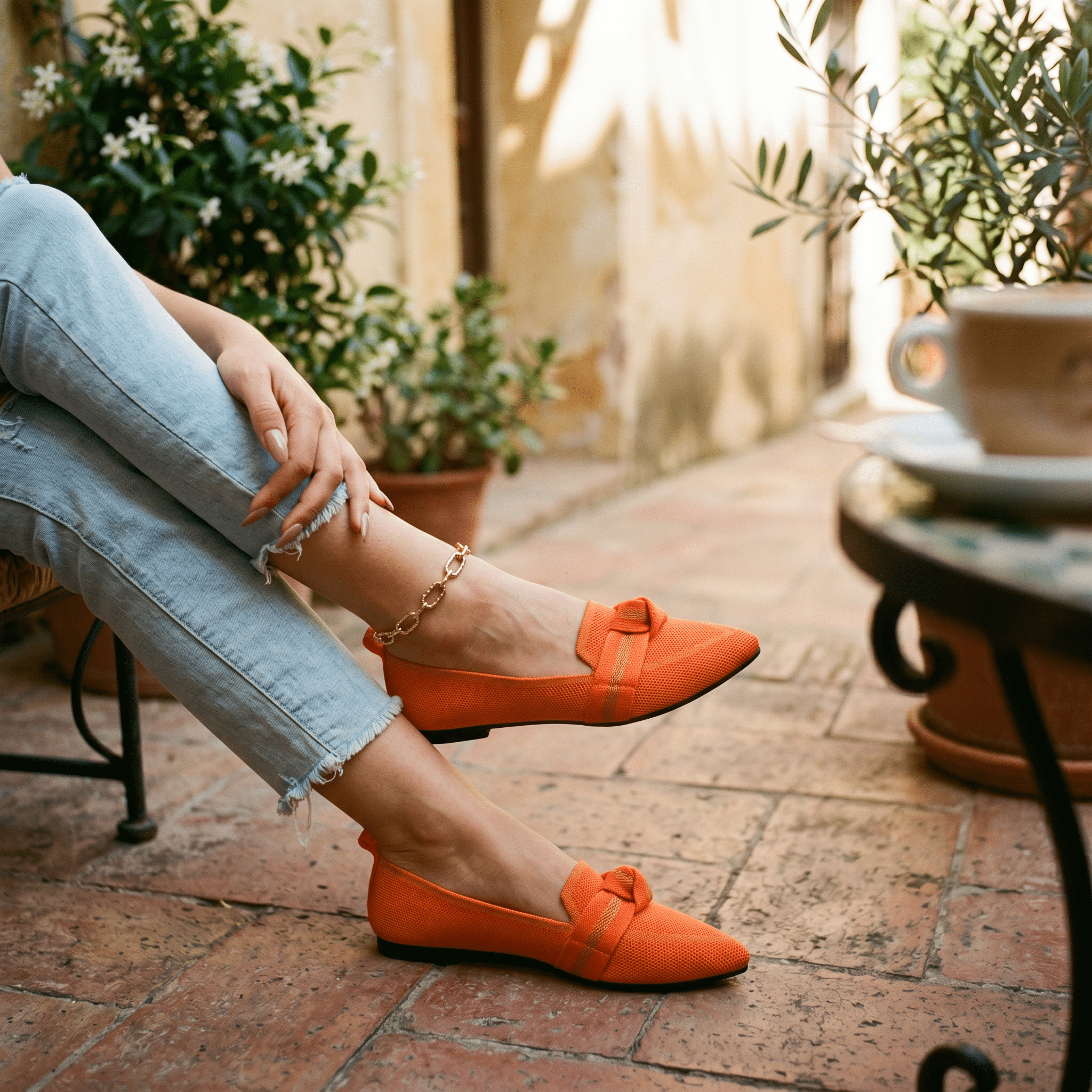 Women’s slip-on loafers in bright orange with bow strap detail and pointed toe