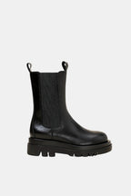 Black Chelsea boots with elastic gore, rugged platform sole, and pull-tab loops