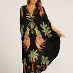 Black kaftan-style dress with colorful bird and palm tropical print, V-neck, flowing drape