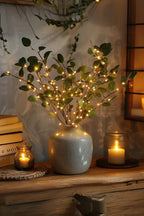 Olive LED branch centerpiece with green leaves, warm white lights, in speckled vase