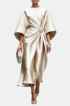 Cream satin maxi dress, boat neck, wide sleeves, front twist with jeweled brooch